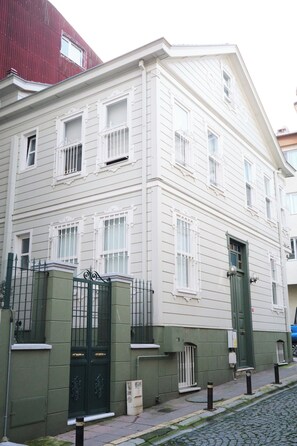 A two-story building with a green gate and a white facade. - A beautiful Historic Mansion in beautiful Istanbul. Spacious 3-bedroom building (İstanbul)