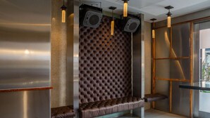 A modern waiting area with a tufted leather bench, a glass partition, and pendant lighting. - Near One World Trade Center + Free Wi-Fi (New York)