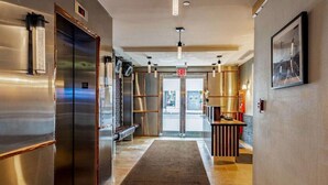 A hallway with a central exit door, a reception desk, and a vending machine. - Near One World Trade Center + Free Wi-Fi (New York)