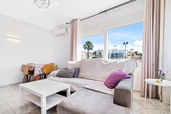 Departamento Confort, balcón, vista parcial al mar | Área de sala de estar | Televisión 