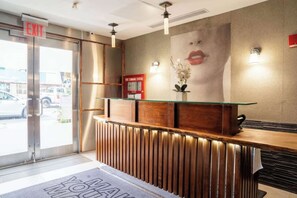 Een receptiebalie met een glazen blad, houten lambrisering en een bord met daarop een melding over brandveiligheid.