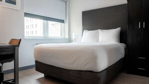 Een moderne hotelkamer met een groot bed, een bureau en een kledingkast.