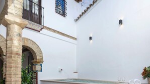A courtyard with a fountain, potted plants, and a staircase leading to an upper level. - Exclusive 5 Rooms Traditional House in Cordoba. Casa San Pedro (Córdoba)