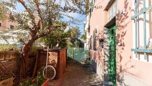 A narrow alleyway with a tree, a wooden structure, and a green door. - GuestHost - A practical 20 square meters studio apartment, perfect for two people, located on the ground floor of a building with a private entrance.The property is located in the Nervi neighborhood, just 400 meters from Caprafico beach, making it easy f (Genoa)