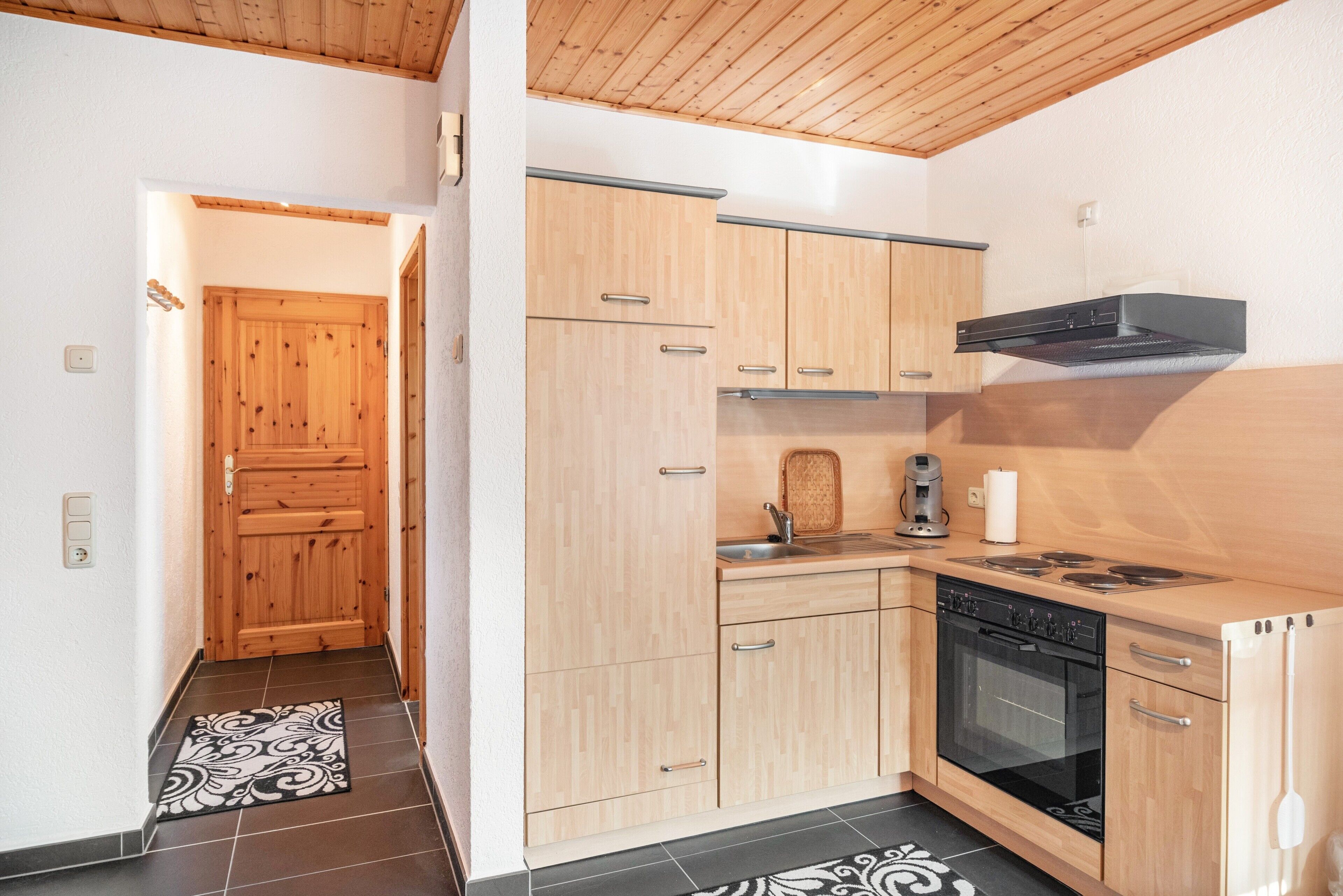 A modern kitchen with wooden cabinets, a stove, and a sink.