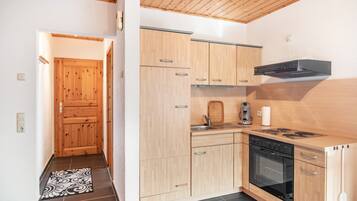 A modern kitchen with wooden cabinets, a stove, and a sink.