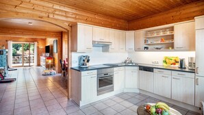 A modern kitchen with wooden cabinets, a built-in oven, and a sink. - Holiday Home 'Landhaus-Eifelhöhe' with Private Terrace, Private Garden and Wi-Fi (Schüller)