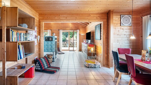 A wooden interior with a dining area, bookshelves, and a sofa. - Holiday Home 'Landhaus-Eifelhöhe' with Private Terrace, Private Garden and Wi-Fi (Schüller)