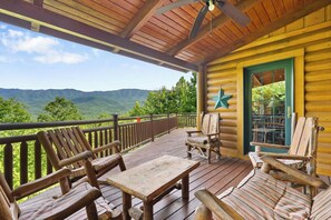 A wooden deck with outdoor furniture, a star decoration, and a view of mountains. - Among the Clouds | By Colonial Properties (Gatlinburg)