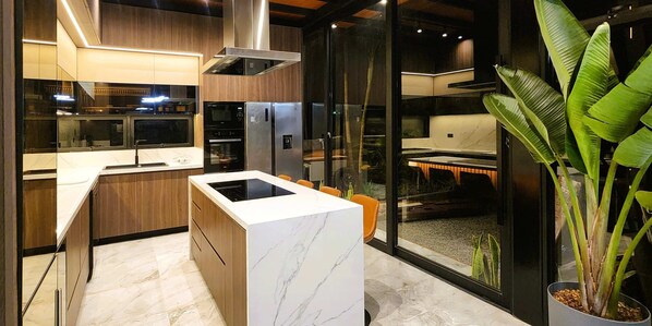 A modern kitchen with a built-in oven, a stainless steel refrigerator, and a marble countertop. - w Private 4BR Getaway With Pool Cinema (Salas)