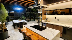 Una cocina moderna con encimera de mármol, armarios de madera y lavavajillas integrado.