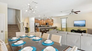 Ein modernes Wohnzimmer mit Essbereich, Küche und Treppe.