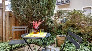 A patio with a round table, two chairs, a bench, and a potted plant. - Apartment, 33 sqm, up to 2 guests with private terrace and Wi-Fi (Baden-Baden)