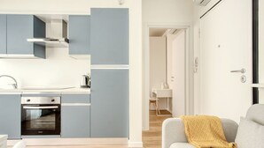 A modern kitchen with grey cabinets, a built-in oven, and a coffee machine. - Hostmate - Milano - Imperia's Pearl - Romolo IULM (Milano)