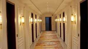 A long hallway with doors on both sides, each with a wall-mounted light fixture. - Majestic Castle (Ludhiana)