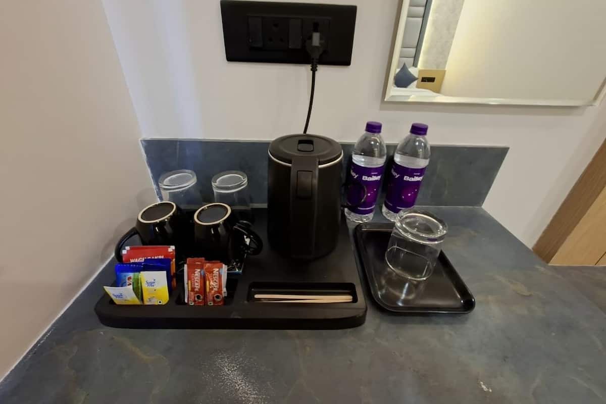 A coffee station with a coffee maker, cups, and various coffee pods.