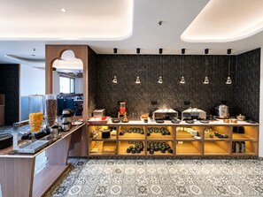 Une cuisine moderne dotée d’un bar pour prendre le petit-déjeuner, d’un coin café et d’une variété de produits alimentaires.
