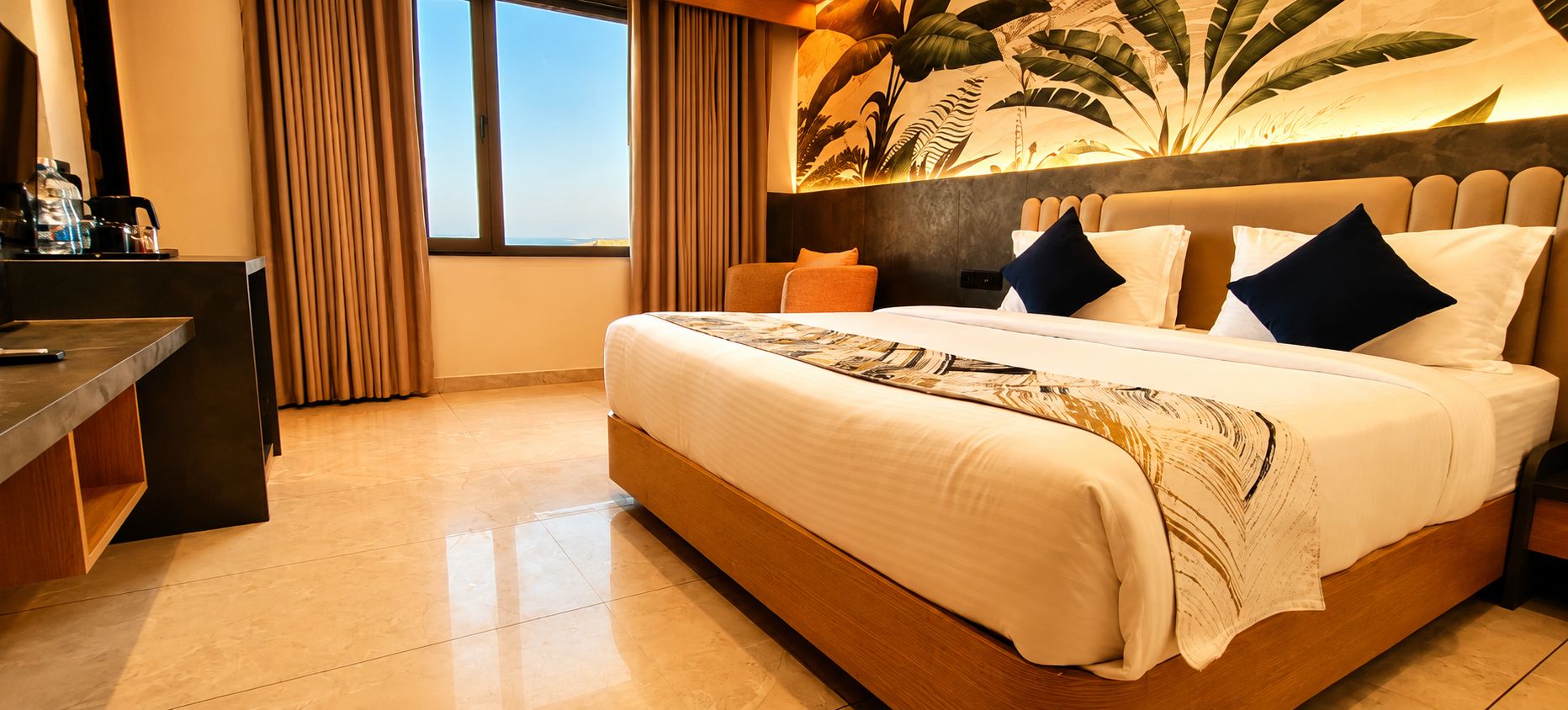Habitación de hotel con una cama grande, un escritorio con silla y vistas al exterior a través de una ventana.