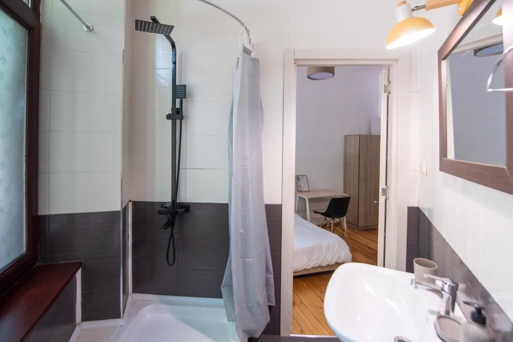 Un baño moderno con ducha, lavabo y espejo.