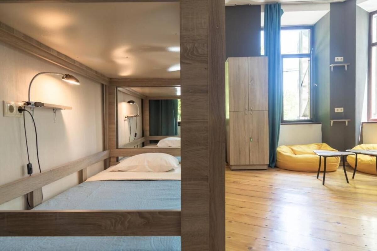 A modern room with a bed, a desk, a wardrobe, and a window with curtains.