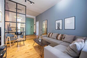 A modern living room with a sofa, coffee table, and a bookshelf. - City guli brosse (Tbilisi)