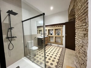 A modern bathroom with a glass shower enclosure, a white toilet, and a patterned floor. - Exclusive 5 Rooms Traditional House in Cordoba Casa San Pedro (Córdoba)