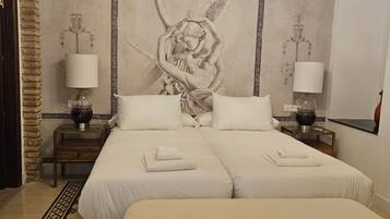 A double bed with a large wall mural, two bedside tables with lamps, a bench, and a patterned rug.