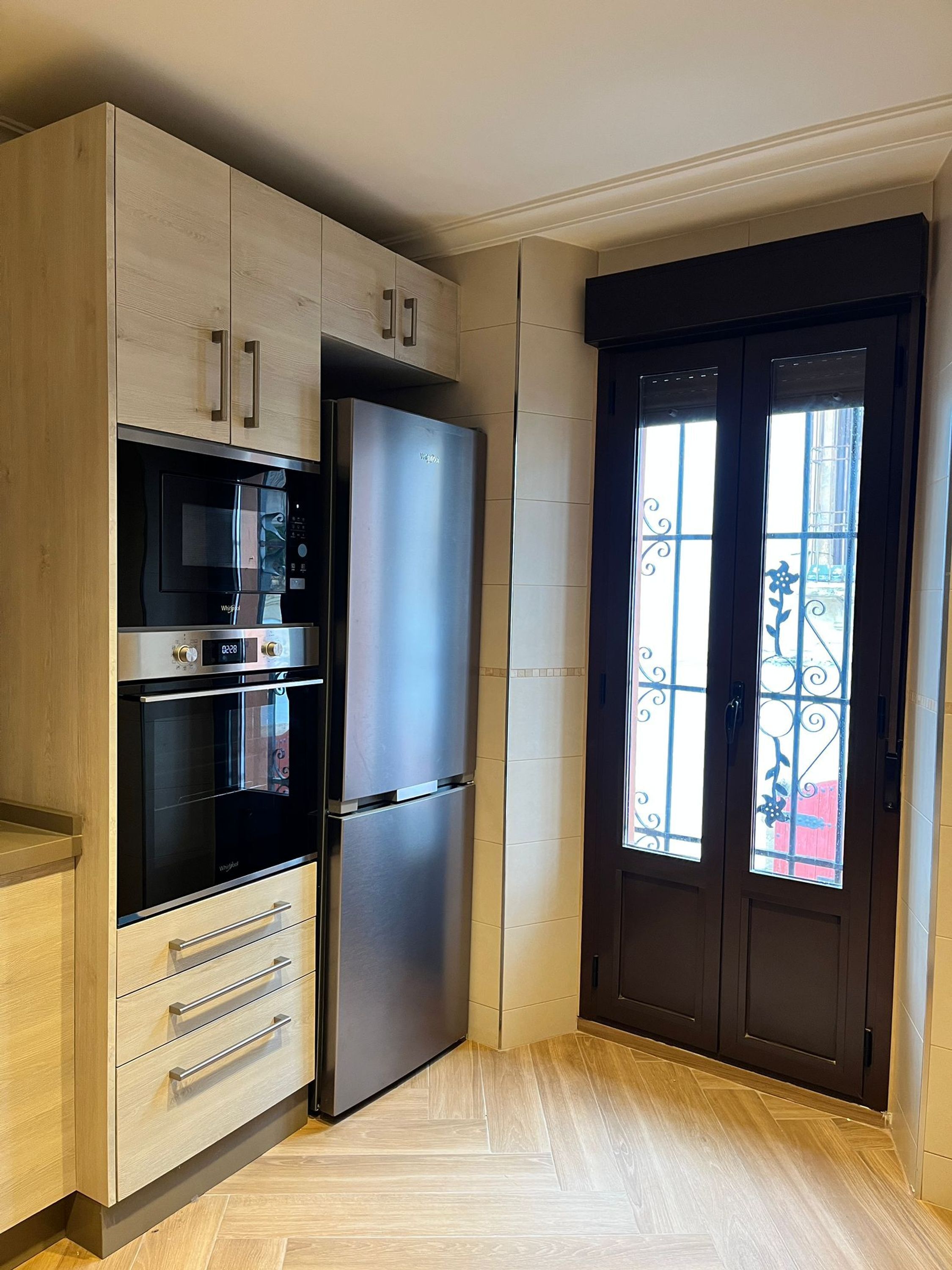 A compact kitchen with a built-in microwave, oven, and refrigerator.