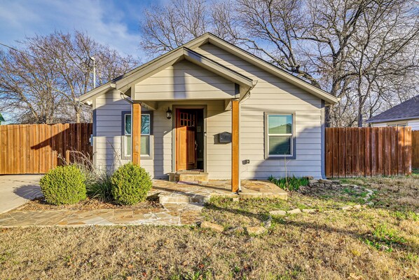 A single-story house with a front porch, a wooden fence, and a well-maintained lawn. - Family-friendly Gem 1 Mi to Historic Dtwn Mckinney (McKinney)