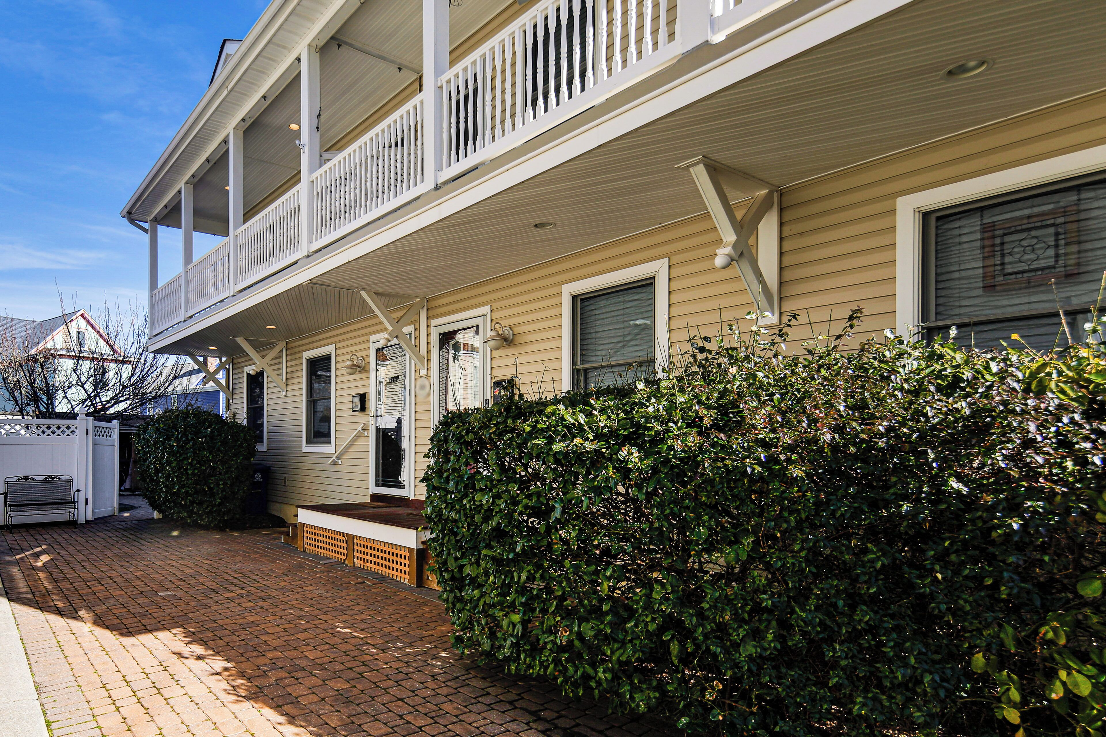 A two-story house with a covered front porch and a small front yard.
