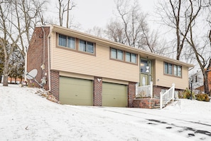 A two-story house with a garage, a front porch, and a snow-covered lawn. - Remote-work Ready: Family Home Near Pittsburgh (Monroeville)