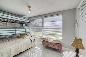 A room with a bunk bed, a bench with pillows, a lamp, and a window with blinds. - 6 Mi to Hudson Beach! Pet-friendly Retreat w/ Yard (Port Richey)