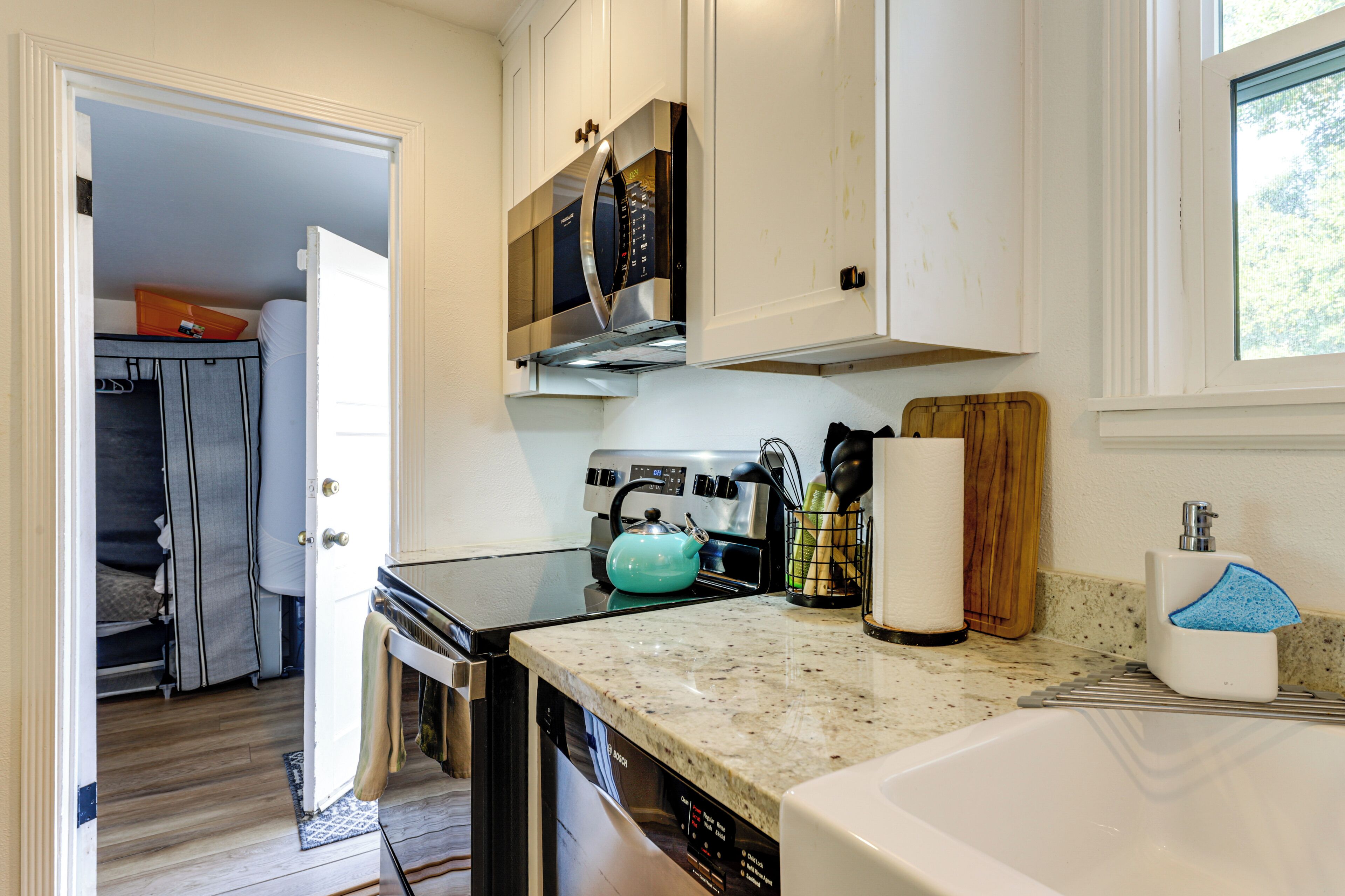 A kitchen with a dishwasher, stove, and a window.