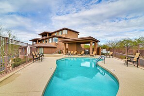 A pool area with lounge chairs and a building in the background. - Pool Access: Mtn-view Getaway in Fountain Hills! (Fountain Hills)
