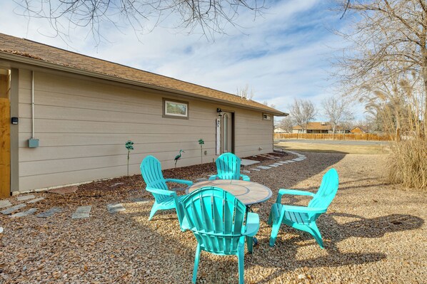 A house with a gravel patio, a wooden deck, and a small garden area with chairs and a table. - 4 Mi to Dtwn! Grand Junction Stay w/ Private Pool (Grand Junction)