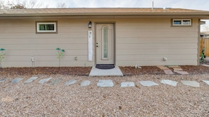 A single-story house with a beige exterior, a front door with a green door frame, a small window above the door, and a mailbox on the right side. - 4 Mi to Dtwn! Grand Junction Stay w/ Private Pool (Grand Junction)