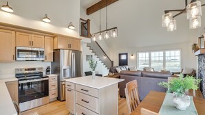 Una cocina amplia con electrodomésticos modernos, una isla central y una sala de estar acogedora con chimenea.