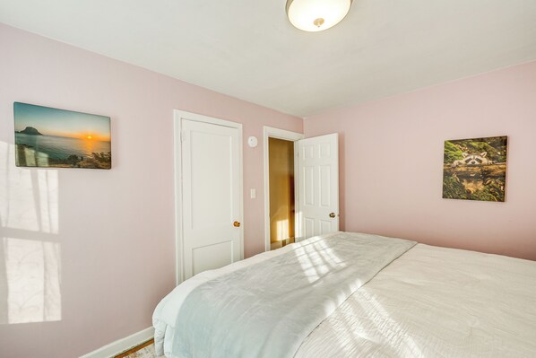 A bedroom with a bed, two doors, and two wall-mounted pictures. - 5 Mi to Dtwn Rockford: Pet-friendly Home w/ Yard! (Loves Park)