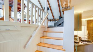 A wooden staircase with white railings leading to a landing. - Hike, Fish & Ski: Riverside Barn Loft in Lee (South Lee)