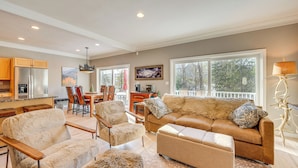 A spacious living area with a large sofa, two armchairs, and a coffee table. There is a dining area with a table and chairs, and a kitchen with a refrigerator and cabinets. - Upscale Retreat at Loon Mountain! Family Townhome (Lincoln)