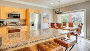 A spacious kitchen with granite countertops, stainless steel appliances, and wooden cabinets. - Upscale Retreat at Loon Mountain! Family Townhome (Lincoln)