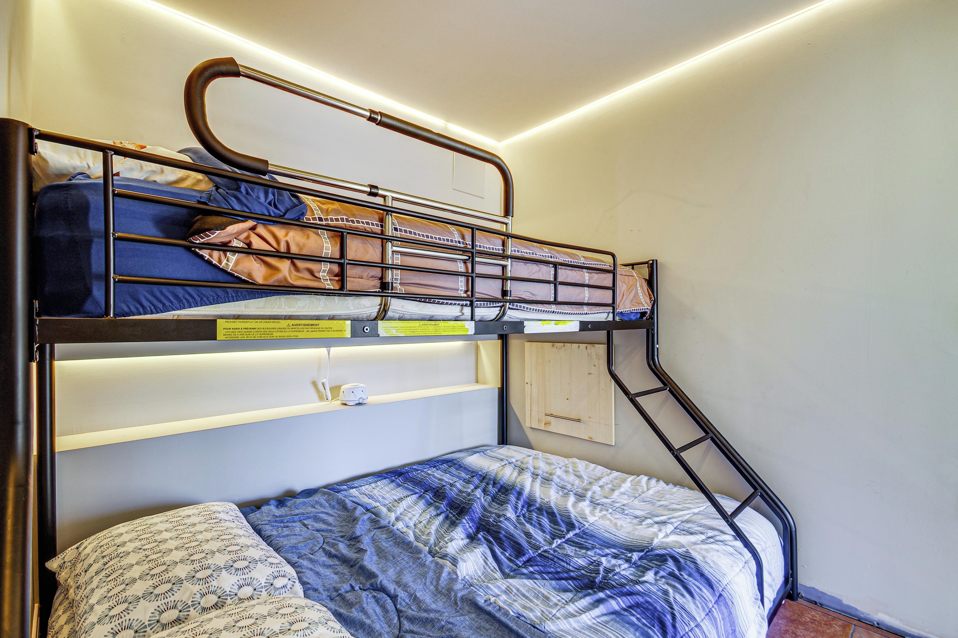 A bunk bed with a ladder, a shelf, and a small clock.