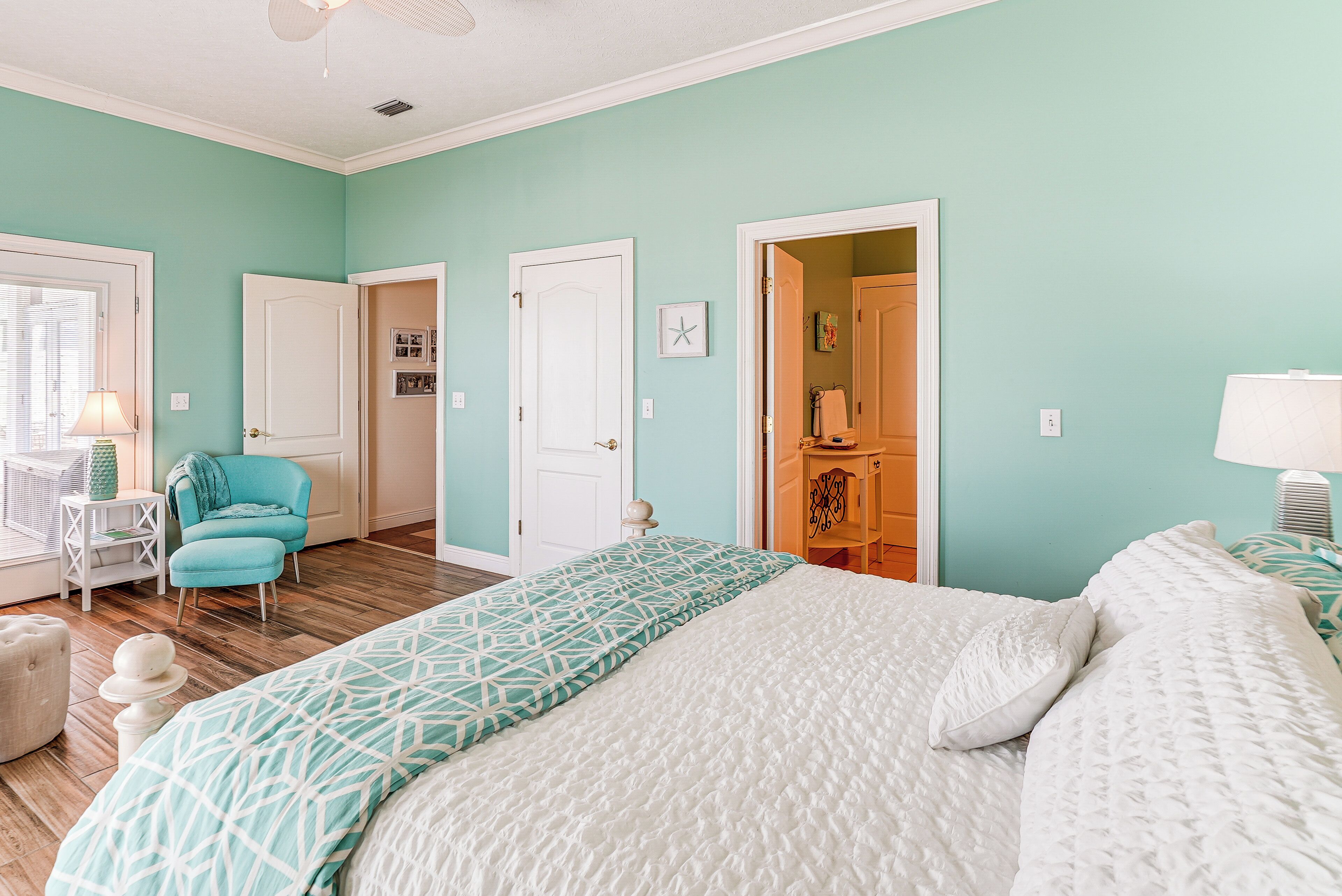 A bedroom with a bed, a chair, a desk, and a wardrobe.