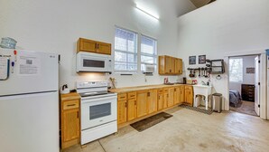 A kitchen with wooden cabinets, a white refrigerator, a microwave, and an oven. - Sportsman's Paradise! St Maries Stay Near Hunting (St. Maries)