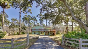 A two-story building with a porch, surrounded by trees and a wooden fence. - 1/2 Mi to Beach! Rural Home w/ Deck in Port St Joe (Port St. Joe)
