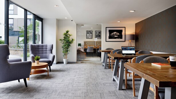 A modern conference room with grey upholstered chairs, a wooden table, and a laptop. - For Students Only Ensuites in Southampton (Southampton)