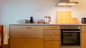 A modern kitchen with wooden cabinets, a built-in oven, and a stainless steel range hood. - Vytina Traditional Loft Mezzanine w/ Mt Menalon Views 5 minutes from town center (Vytina)