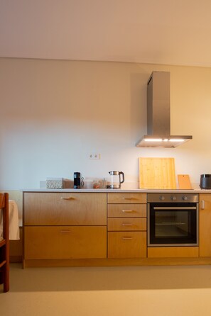 A modern kitchen with wooden cabinets, a built-in oven, and a stainless steel range hood. - Vytina Traditional Loft Mezzanine w/ Mt Menalon Views 5 minutes from town center (Vytina)