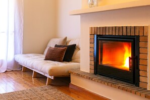 A cozy living room with a fireplace, a sofa, and a rug. - Vytina Traditional Loft Mezzanine w/ Mt Menalon Views 5 minutes from town center (Vytina)