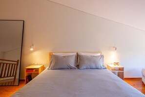 Ein Schlafzimmer mit einem großen Bett, zwei Nachttischen und einem Holzkopfteil.
